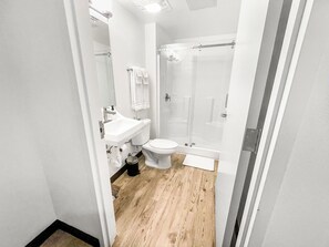 Moderni kylpyhuone, jossa on suihku, wc ja pesuallas.