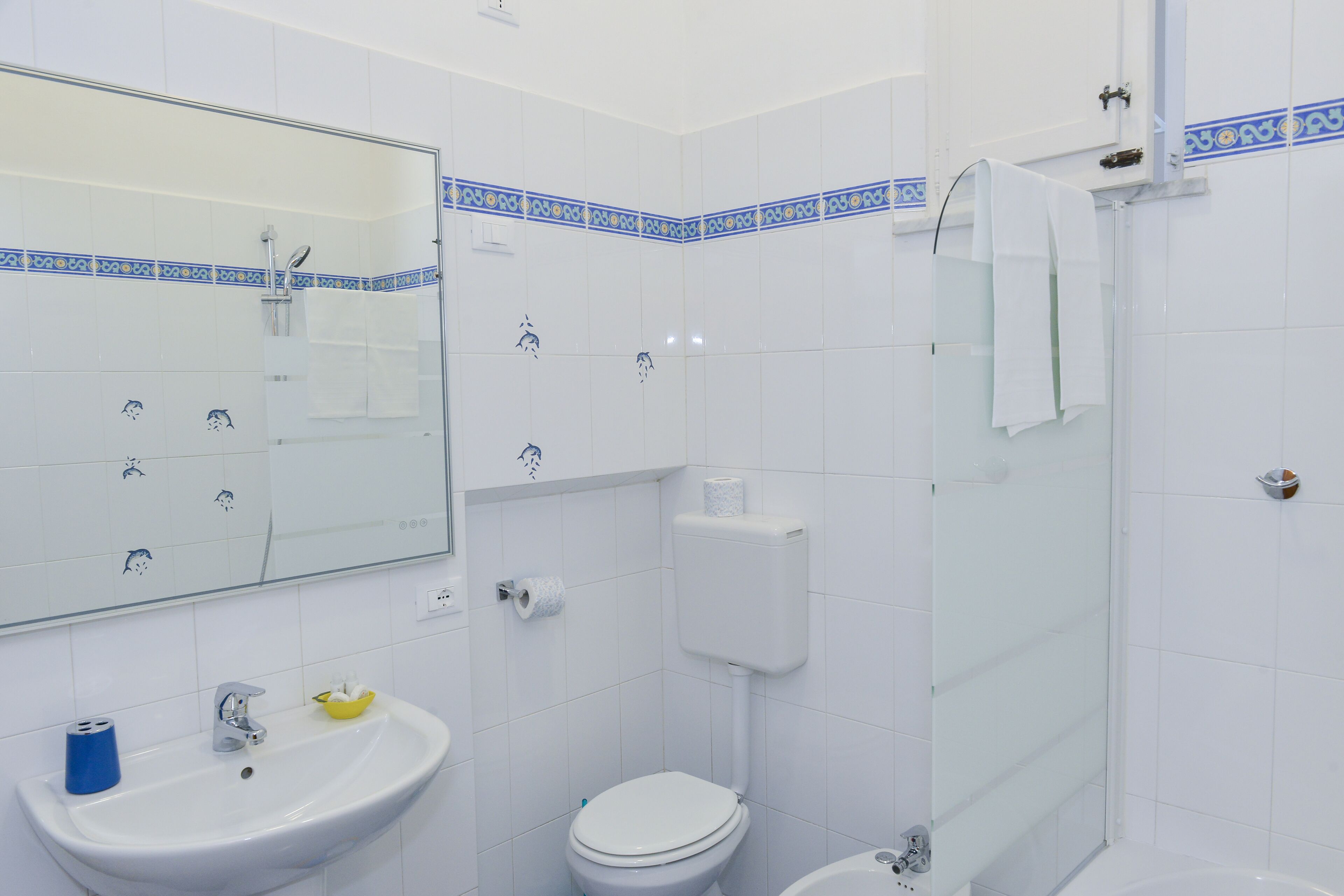 Un baño con lavamanos, inodoro y ducha.