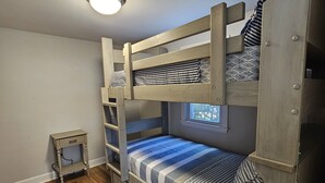 A bunk bed room with a small window, a bedside table, and a ceiling light. - Newly Renovated Mid-Cape Home with Pond and Waterfront Access (Dennis)