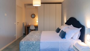 Une chambre à coucher comprenant un lit, une table de chevet, une lampe et un bureau avec une chaise.