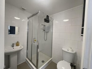 A modern bathroom with a glass-enclosed shower, a sink, and a toilet. - Immaculate 1-bed Studio in London (London)