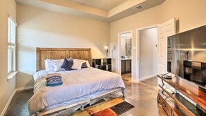 A bedroom with a large bed, a ceiling fan, a TV, and a walk-in closet. - Home away from home (Seguin)