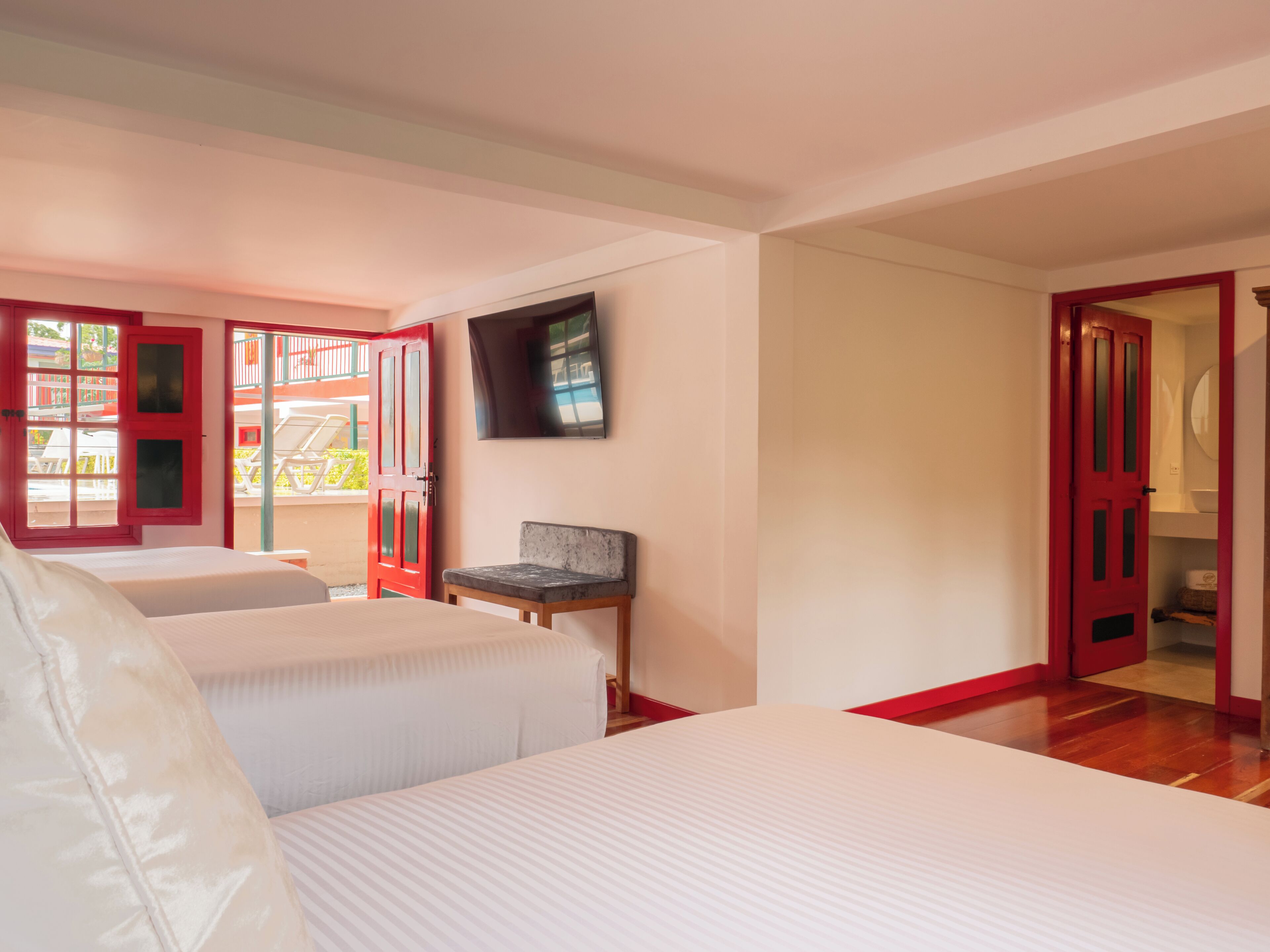 Ett hotellrum med två sängar, en TV och utsikt över balkongen.