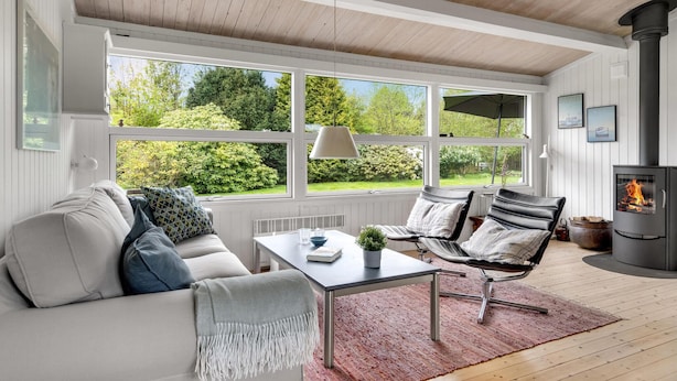 A cozy living room with a sofa, two chairs, a table, and a fireplace. - Cozy home in Idestrup with WiFi (Idestrup)