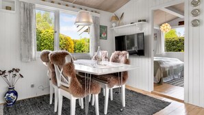 A cozy room with a dining table, chairs, a TV, and a bed. - Cozy home in Idestrup with WiFi (Idestrup)