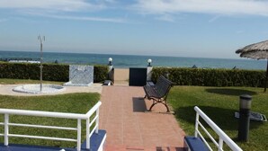 Un espace extérieur aménagé avec un banc, une petite piscine et une vue sur l’océan.