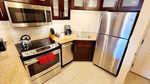 A modern kitchen with stainless steel appliances, including a microwave, oven, and refrigerator.