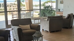 A modern living room with a large window, a coffee table, and two sofas.