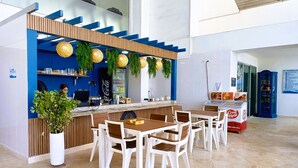 Ein moderner Barbereich mit Theke, Sitzgelegenheiten und einem Blumentopf.