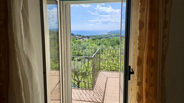 A balcony with a metal railing, a clear view of greenery and a distant coastline. - S320 - Sirolo, one bedroom apartment with breathtaking view (La Madonnina)