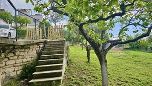 A stone staircase leading to a wooden deck, surrounded by greenery and a fence. - S319 - Sirolo, three-room apartment with sea view and garden (La Madonnina)