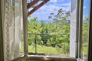 A room with a view of a lush green landscape and a clear sky.