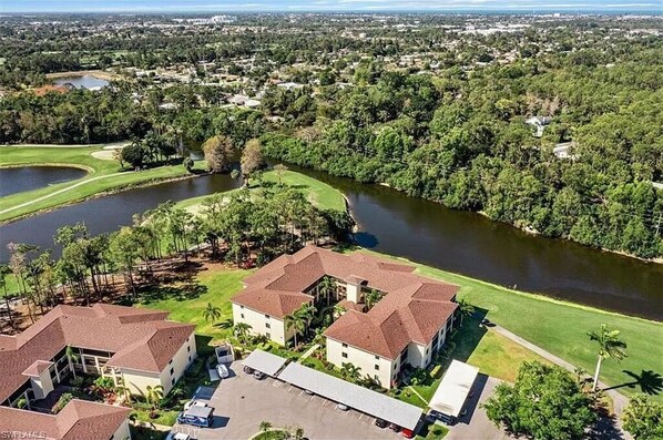 Stunning building with a symmetrical roofline, set amidst lush greenery and a serene golf course.