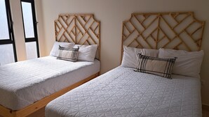 Two twin beds with wooden frames and a geometric patterned bedspread.
