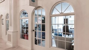 A hallway with arched windows and a sign reading "Palm Beach."