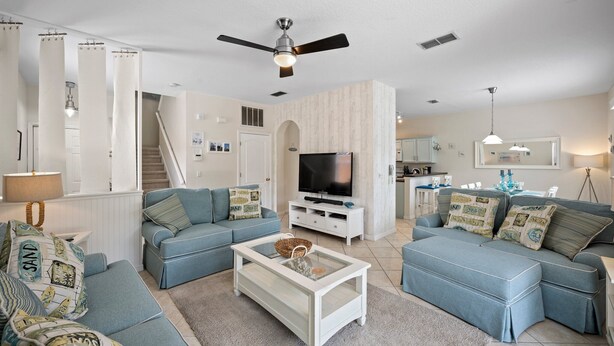 A modern living room with a sectional sofa, a coffee table, a TV, and a ceiling fan. - Magical getaway for the entire Family. (Davenport)