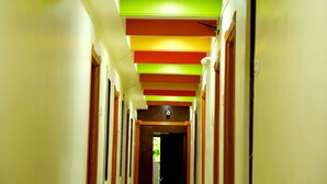 A hallway with a series of doors on either side, leading to individual rooms. - DIVYA LODGE & HOTEL ROOMS (Hyderabad)