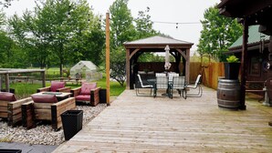 A wooden deck with outdoor furniture, a gazebo, and a greenhouse. - The Lodge at Lakeshore (Emeryville)