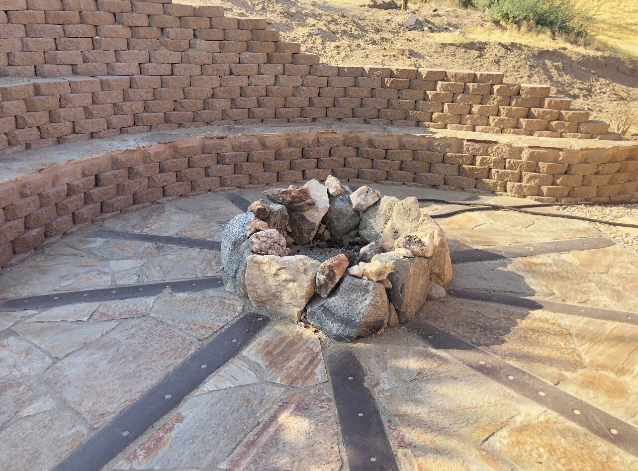 A stone fire pit surrounded by a brick wall.