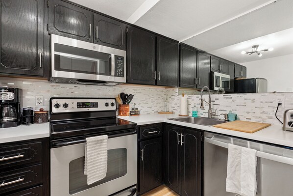 Enjoy cooking in this well-equipped kitchen with a stainless steel range, microwave, and ample countertop space.