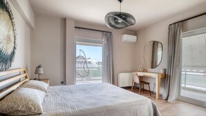 Une chambre d’hôtel moderne, dotée d’un grand lit, d’un bureau, d’une chaise et offrant une vue sur la ville.