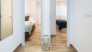 A hallway leading to two bedrooms with wooden flooring and white walls. - 2nd line Boliches Beach Apartment (FUENGIROLA)