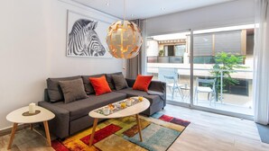 A modern living room with a grey sofa, colorful rug, and a round coffee table. - 2nd line Boliches Beach Apartment (FUENGIROLA)