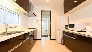 A modern kitchen with stainless steel appliances, a built-in oven, and a microwave. - TEINE HOTEL (Sapporo)