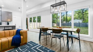 A spacious living area with a dining table, chairs, and a sofa.