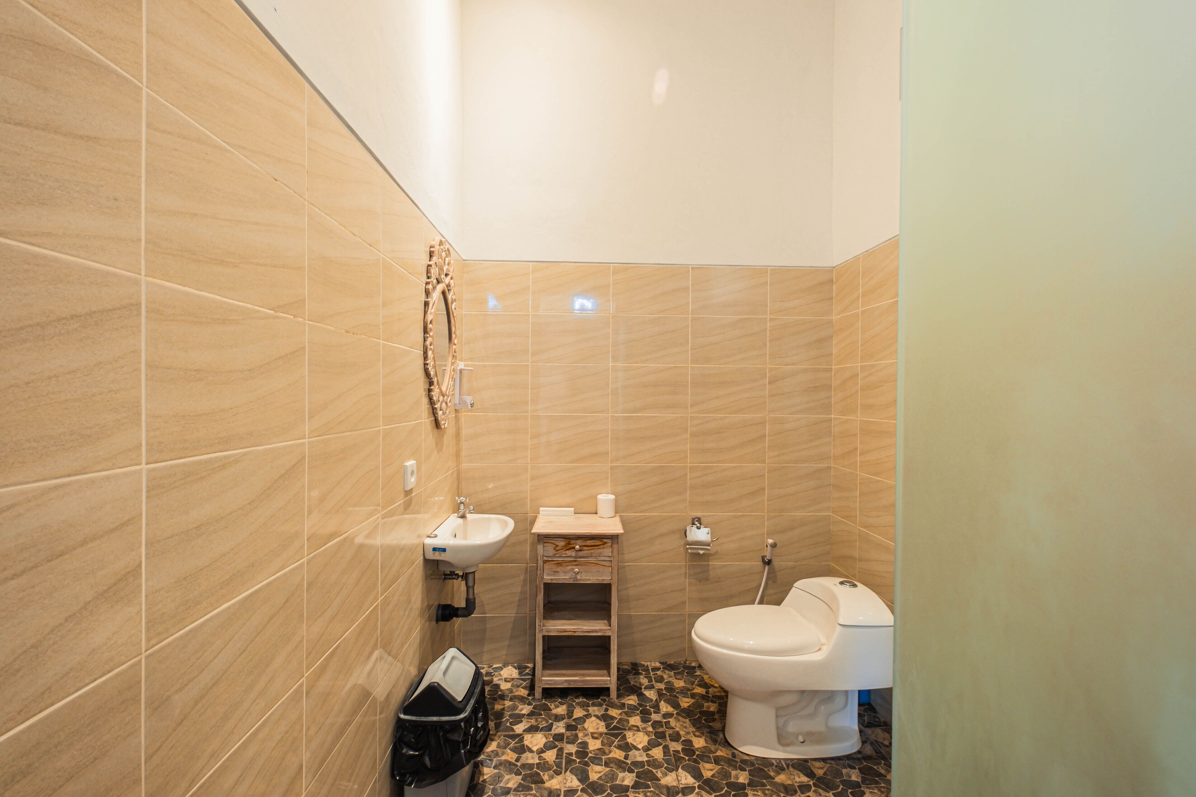 Un baño con inodoro, lavamanos y tocador.