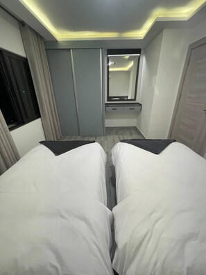 Un dormitorio con dos camas, un espejo y un armario.