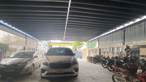Un área de estacionamiento techada con automóviles y motocicletas estacionadas.