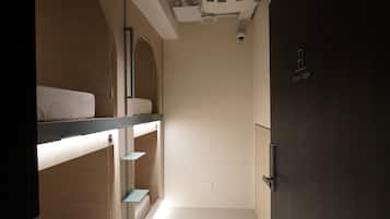 Ein Zimmer mit Etagenbetten, einer Tür mit der Aufschrift "chow room" und einer unter der Decke montierten Klimaanlage.