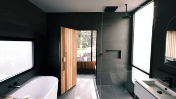 A modern bathroom with a bathtub, shower, and sink.