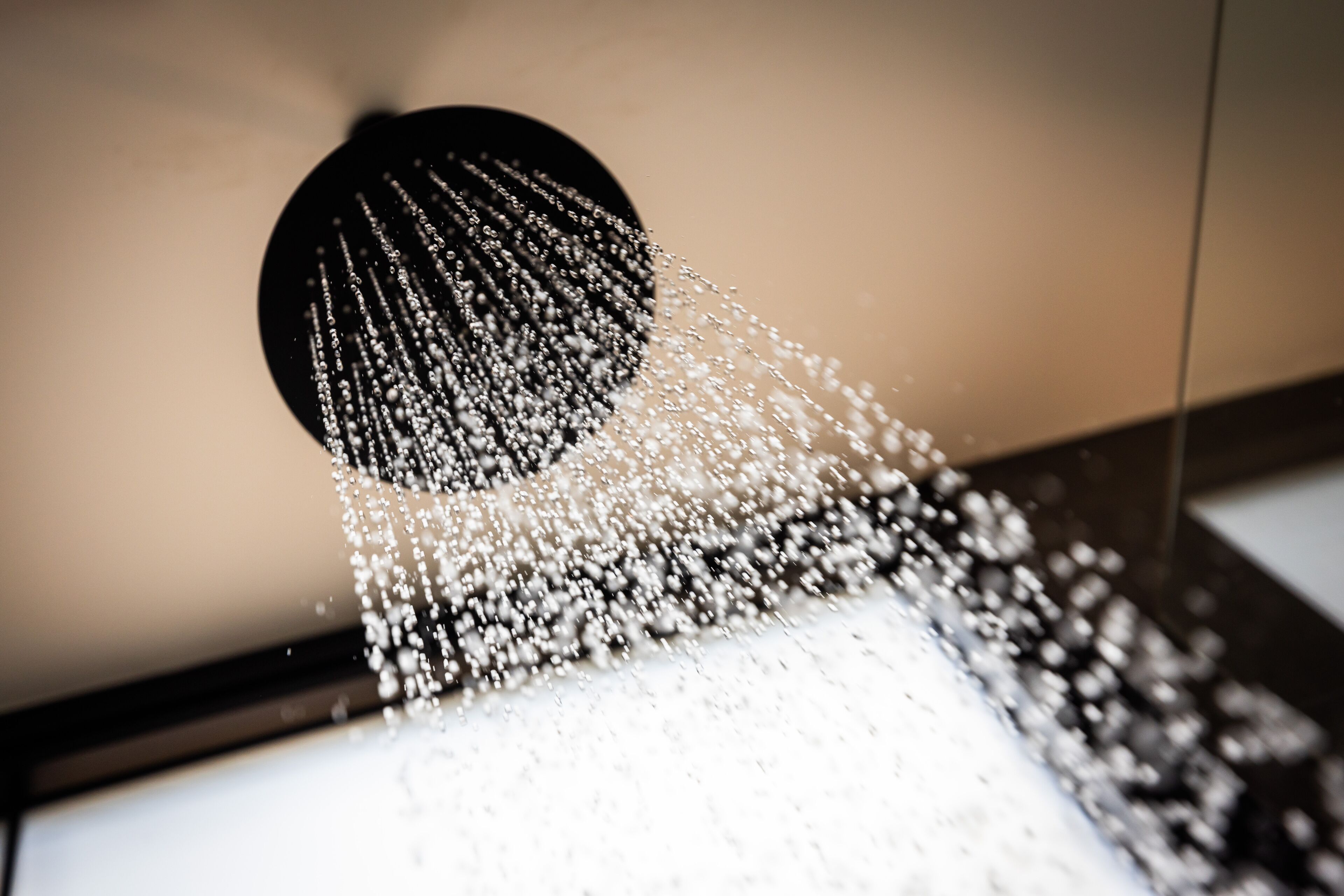 A showerhead with water spraying down.