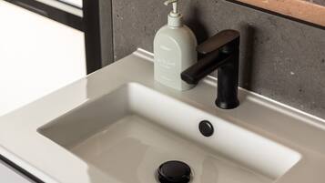 A modern bathroom sink with a soap dispenser and faucet.