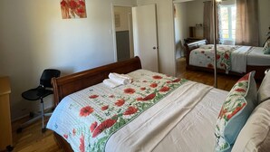 Un dormitorio con una cama grande, un ventilador de techo, un espejo y una silla.