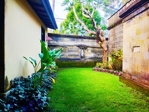 Escape to a serene courtyard surrounded by lush tropical plants and a majestic tree.