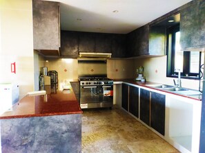 Enjoy cooking in this well-lit kitchen with a central island, stainless steel range hood, oven, and double sink.