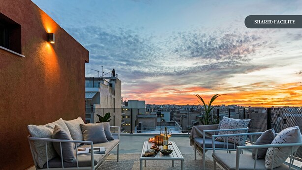 A rooftop terrace with outdoor seating, a table, and decorative lanterns. - Sanders Port - Vibrant Studio Near Piraeus Port (Piraeus)