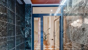 A hotel lobby with a checkered floor, a glass door entrance, and a marble wall. - Sanders Port - Vibrant Studio Near Piraeus Port (Piraeus)