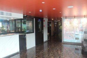 A hotel lobby with a marble floor, a reception desk, a large map display, and a red ceiling. - H-District Boutique Poshotel (Bangkok)
