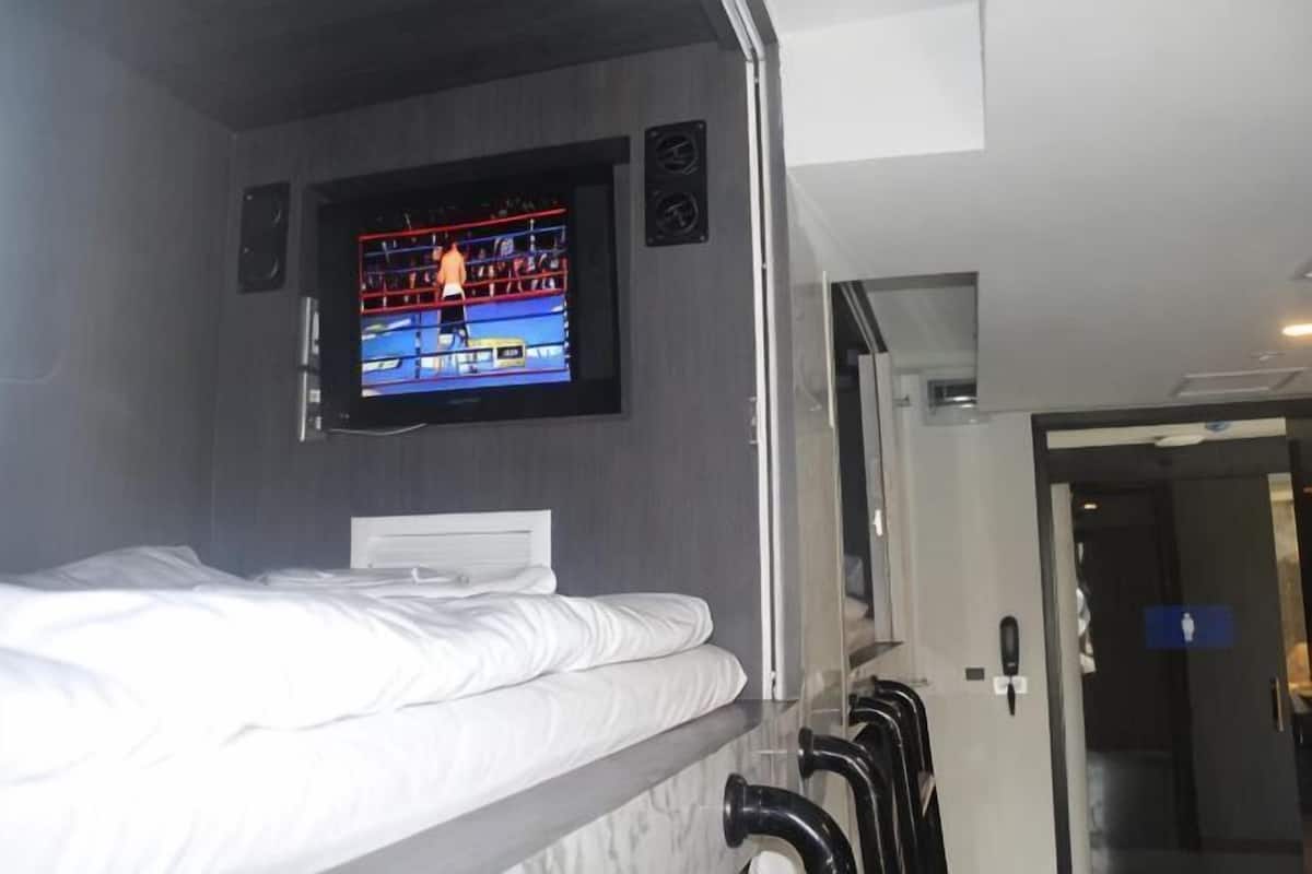 Ein Etagenbett mit einem an der Wand darüber befestigten Fernseher.