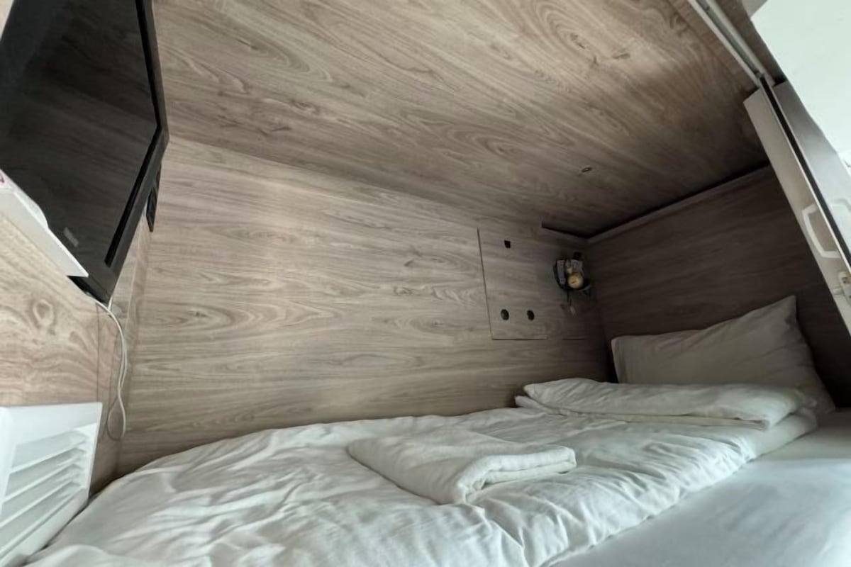 Ein kleines, modernes Schlafzimmer mit Holzbalkendecke und einem Einzelbett.