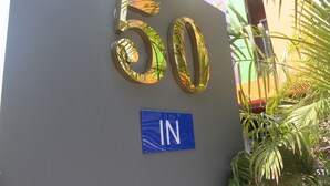 A building entrance with a large number '50' sign and an 'IN' sign below it. - H-District Boutique Poshotel (Bangkok)