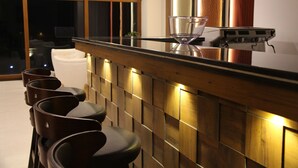 A modern bar area with a wooden counter and bar stools. - Seven Suites thimphu (Thimphu)