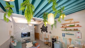 Una sala de estar moderna con un televisor de pantalla plana, asientos cómodos y plantas decorativas.