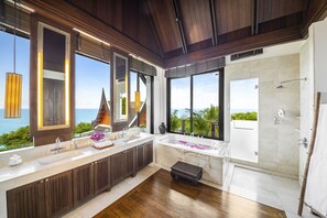 A modern bathroom with a large window, a bathtub, and a shower.