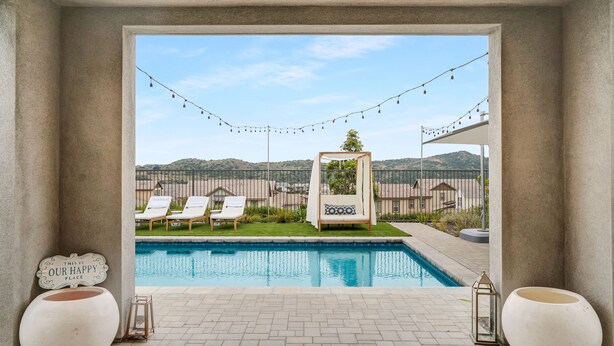 A pool area with lounge chairs, a view of the landscape, and decorative lights. - Resort-like residence with pool, jacuzzi, sauna, ocean breeze & amazing sunsets (Mission Viejo)