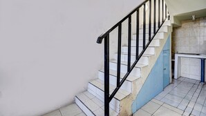 A staircase with black railings and white steps leading to a landing. - Hotel O Kost Umik Sidoarjo Syariah (Sidoarjo)